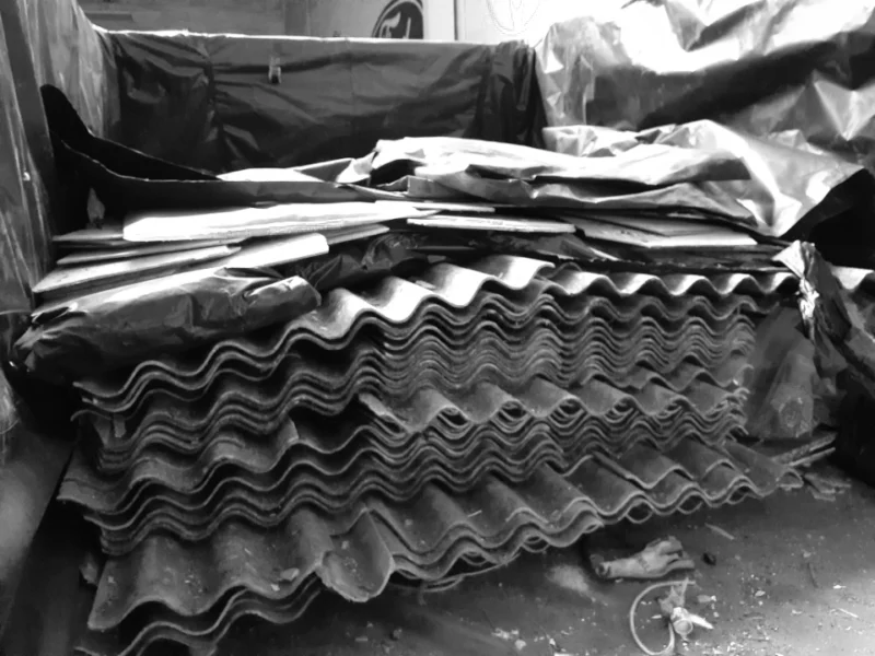 Asbestos roofing sheets wrapped in plastic for disposal