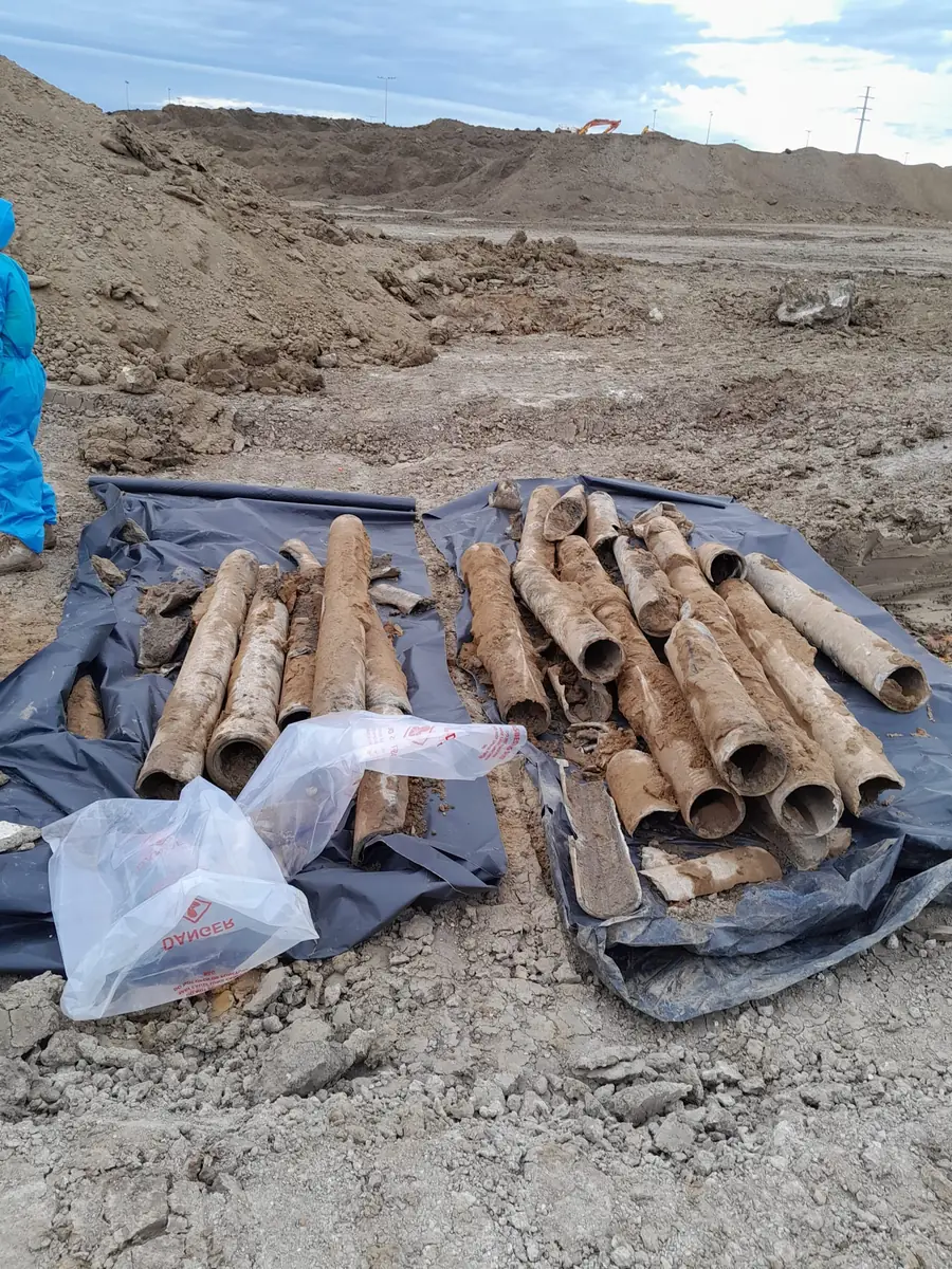 Broken asbestos cement pipes recovered from contaminated soil on plastic sheeting